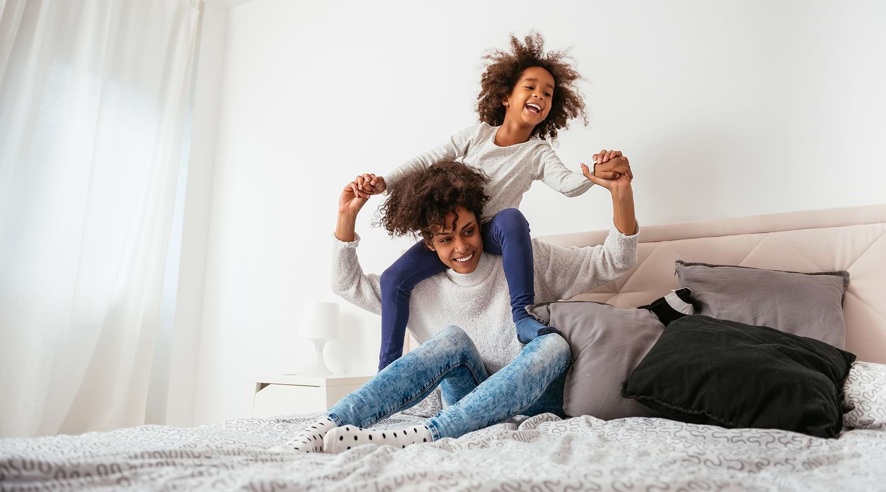 Welcome Home lifestyle image of a mother and child playing in a bedroom
